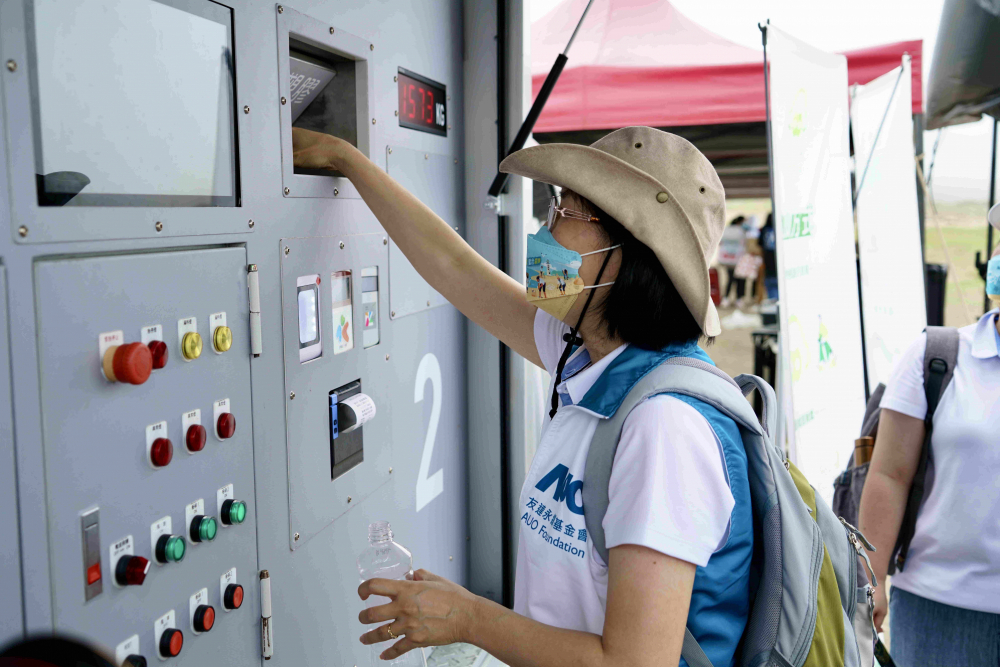 志工們將拾起的寶特瓶投入「好歸塑專車」，讓廢棄塑料空瓶可以直接粉碎、縮小體積，未來將可再製成購物袋、寶特衣、悠遊卡等生活用品